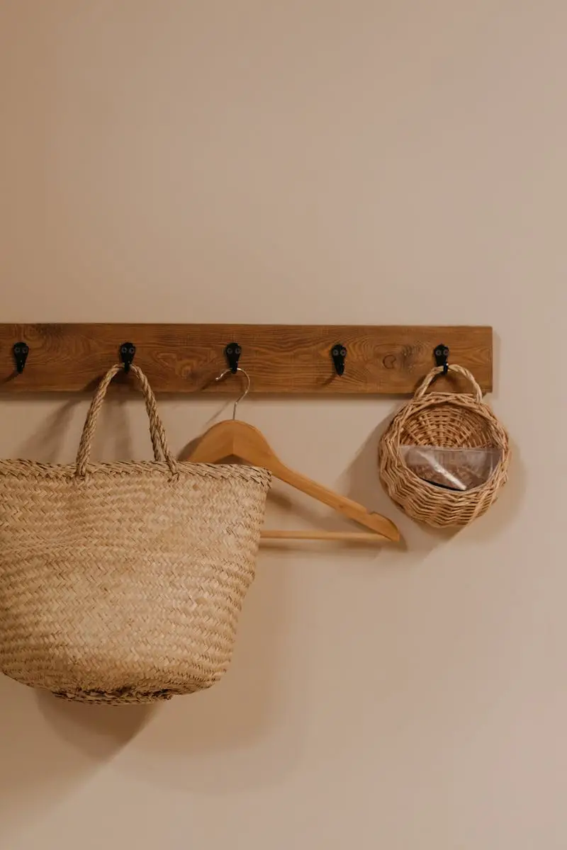 Minimalist interior displaying a woven storage basket and wooden hanger on a rack for natural home decor.